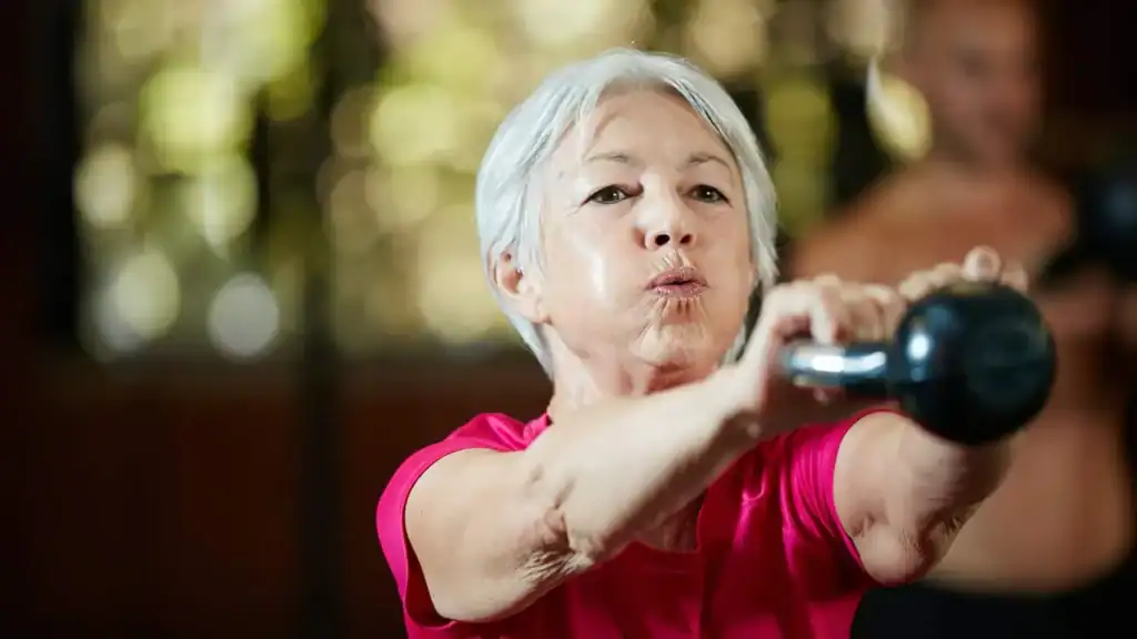Older woman doing weight training Bedford to help her strength and longevity 